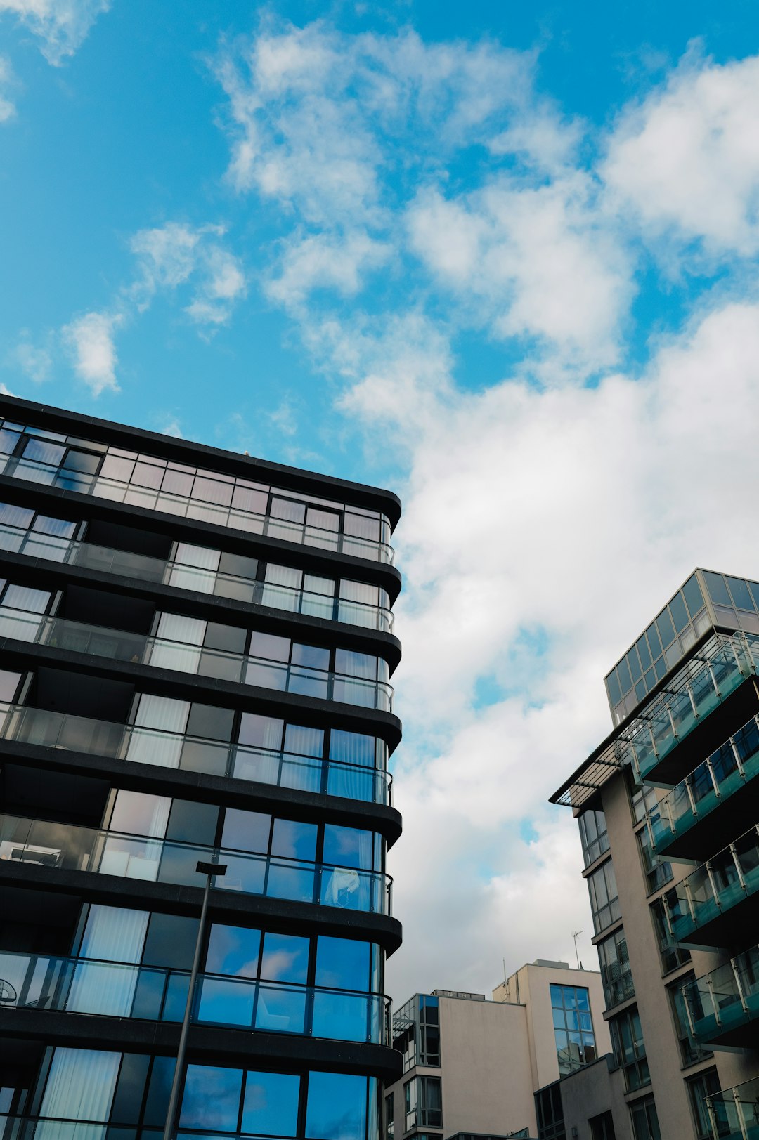 modern-glass-buildings-against-a-blue-cloudy-sky-sqh5lj39t3i